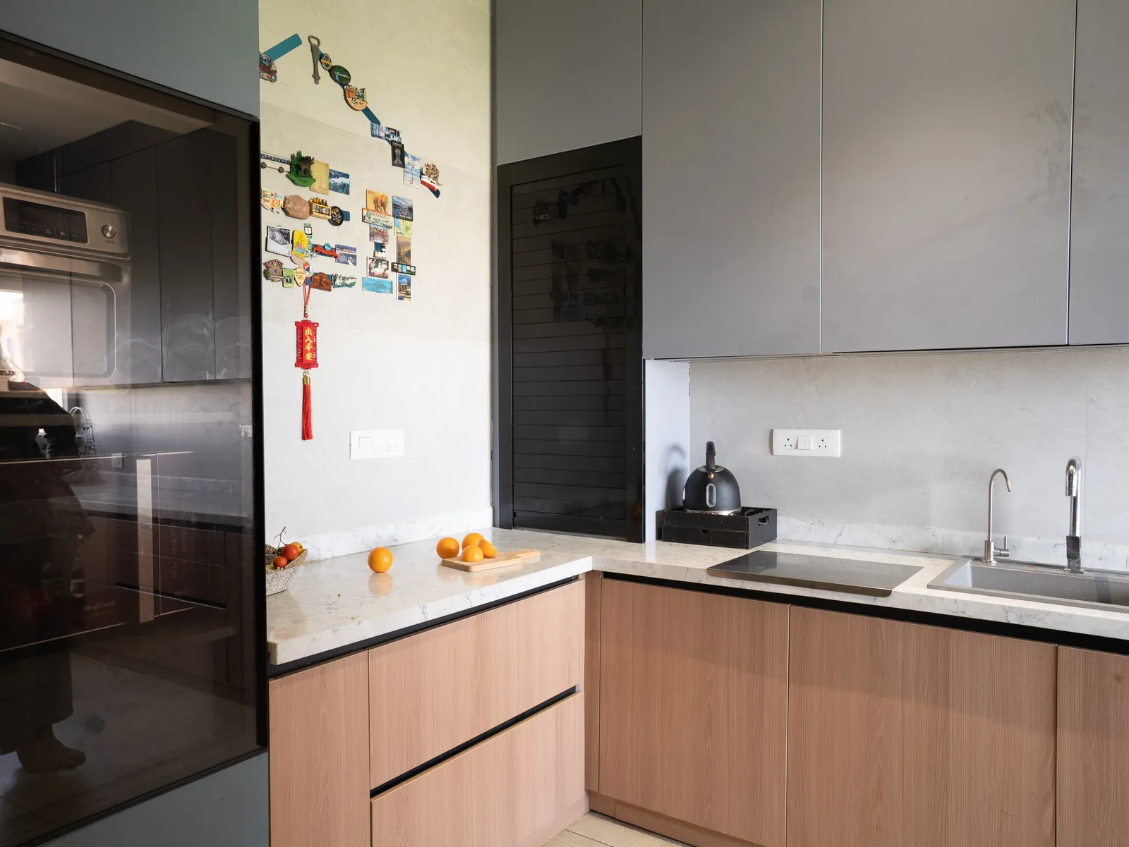 Kitchen with grey and oak cabinets and tall black unit — Amlan's Residence